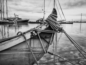 View of ship moored at harbor against cloudy sky