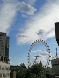 Low angle view of ferris wheel against buildings