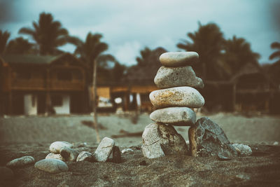 Stack of pebbles at beach against sky