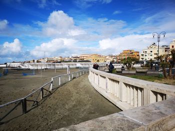 Panoramic view of beach and buildings in town against sky