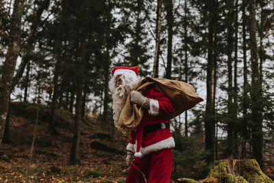 Man wearing santa costume carrying sack