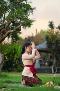 Balinese girl praying with ritual