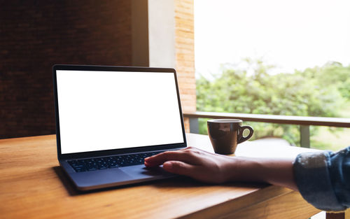 Cropped hands using laptop on table