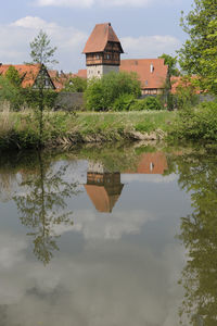 Reflection of built structure in lake against sky