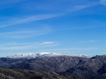 Scenic view of snowcapped mountains against blue sky