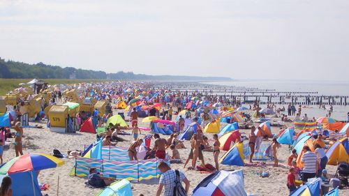 People at beach against sky