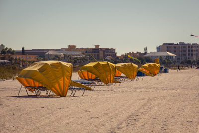 Umbrellas on sand against clear sky