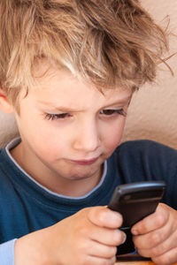 Close-up portrait of boy using mobile phone