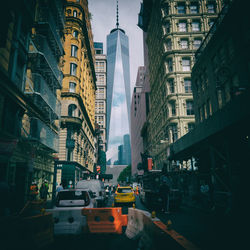Cars on city street against sky
