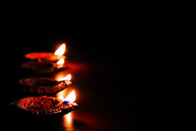 Close-up of lit candle in the dark