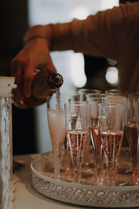 Cropped hand of person pouring champagner on table