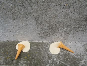 Melted ice cream cone discarded on pavement