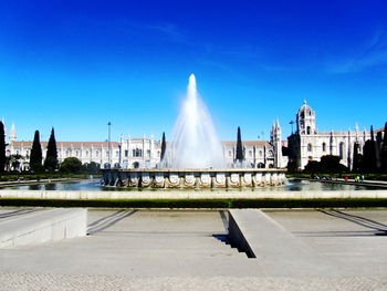 Fountain in city against sky