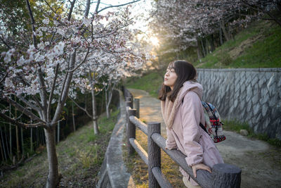 Woman looking away while leaning on railing