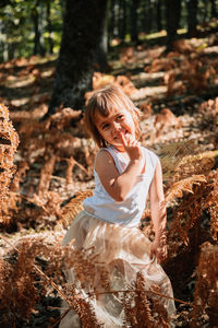 Girl standing on tree trunk in forest