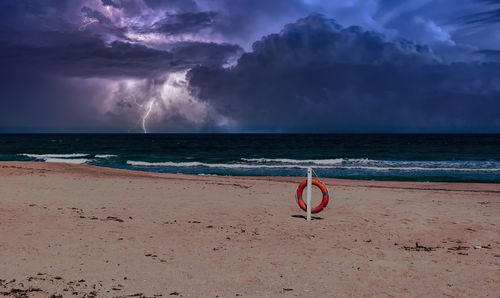 Beach during the storm with lightning and dramatic cloudy sky
