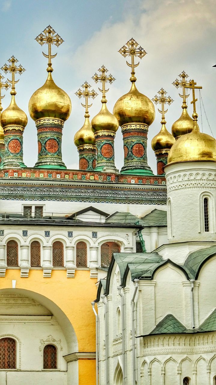 architecture, low angle view, built structure, building exterior, dome, arch, high section, yellow, multi colored, sky, place of worship, facade, outdoors, cloud - sky, exterior, no people, architectural feature, spire, majestic, temple