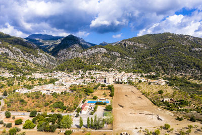 Scenic view of townscape and mountains against sky