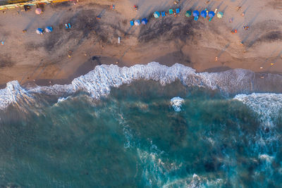 Aerial view of people enjoying on beach against sea