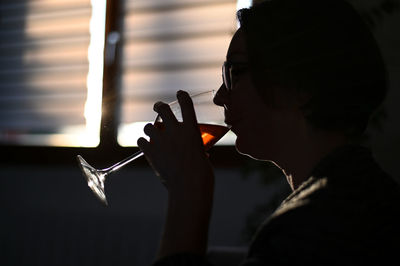 Side view of woman drinking wine