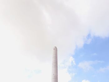 Low angle view of smoke stacks against sky