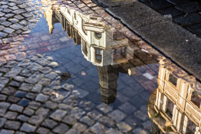 Buildings reflecting in puddle