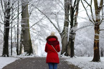 Rear view of woman walking on road during winter