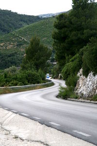 Scenic view of road by mountain against sky