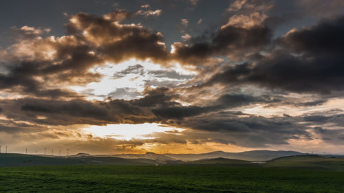 Scenic view of field against sky at sunset