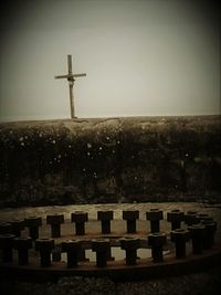 Cross on cemetery against clear sky