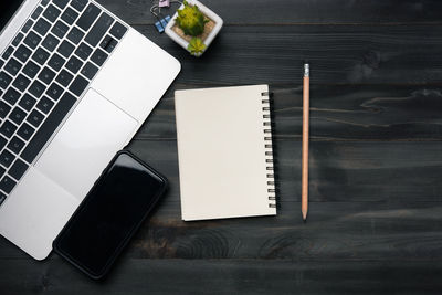 High angle view of laptop and book on table