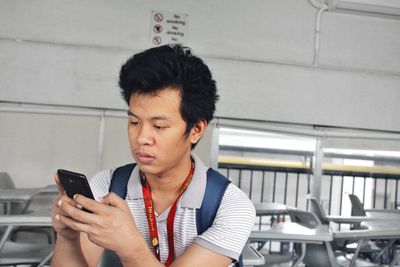 University student using mobile phone in classroom