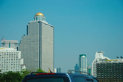 View of buildings against clear blue sky