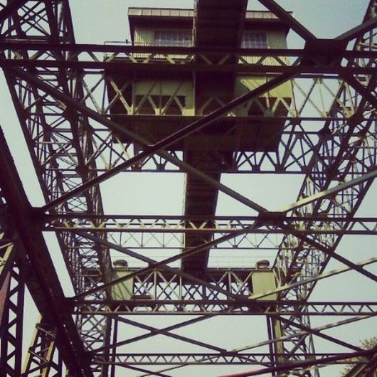 low angle view, built structure, architecture, metal, connection, metallic, sky, clear sky, electricity pylon, grid, day, outdoors, no people, tower, power line, engineering, tall - high, complexity, silhouette, electricity