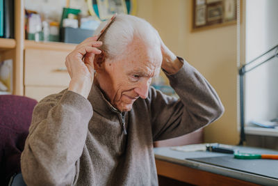 Portrait of man sitting on table at home