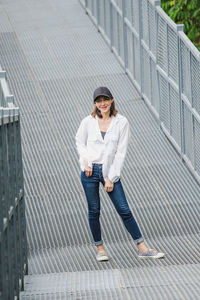 Full length of young woman standing in city