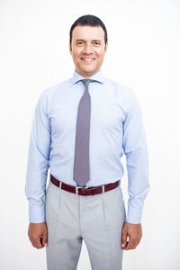 Portrait of smiling man standing against white background