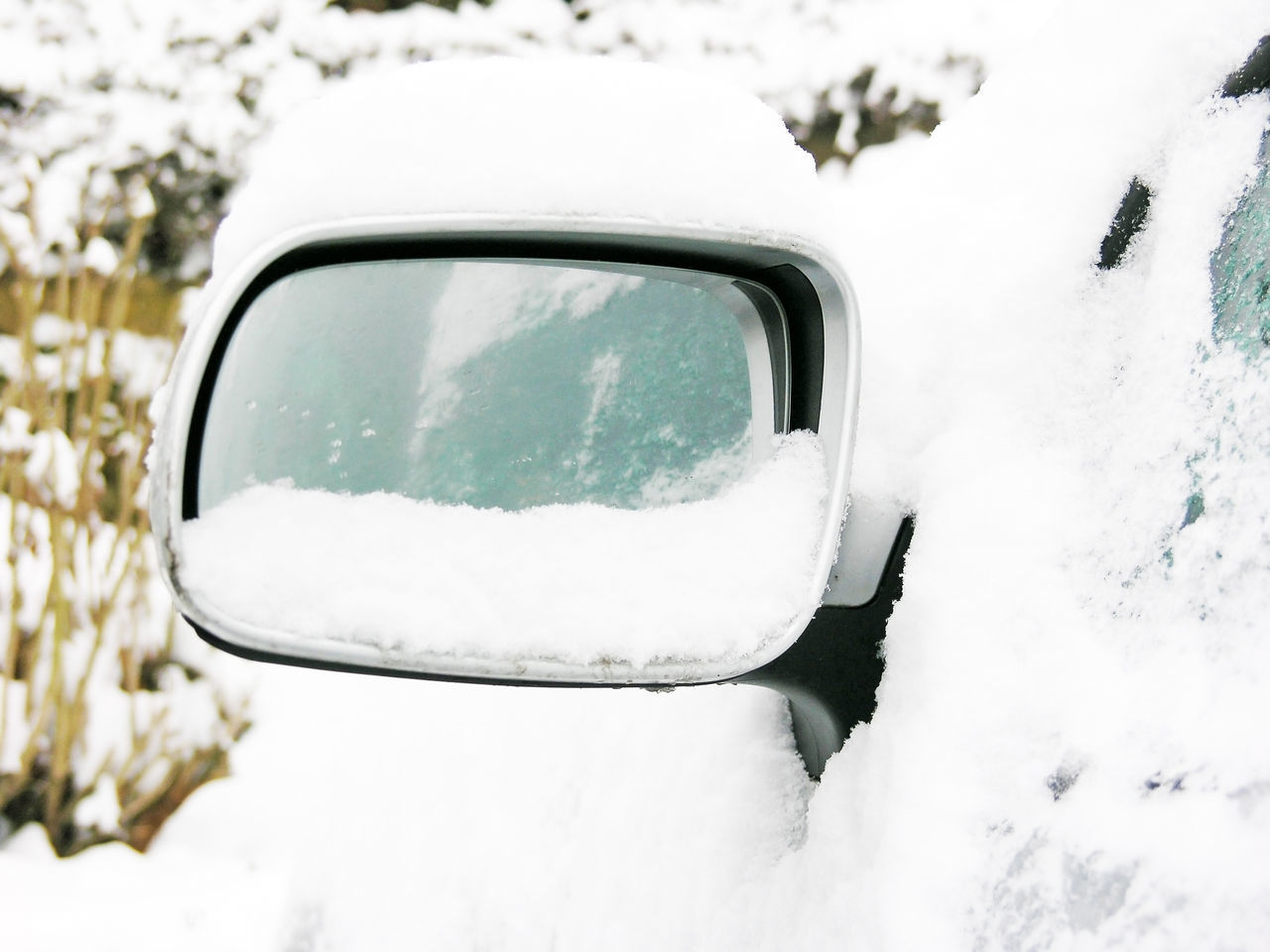 CLOSE-UP OF SNOW COVERED CAR ON LANDSCAPE