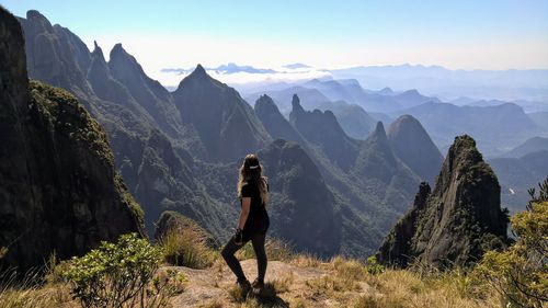 Woman standing on mountain against sky