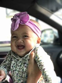 Portrait of cute baby girl in car