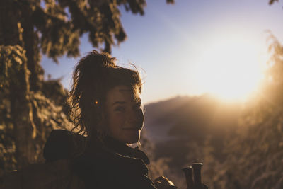 Woman looking back at camera at sunset