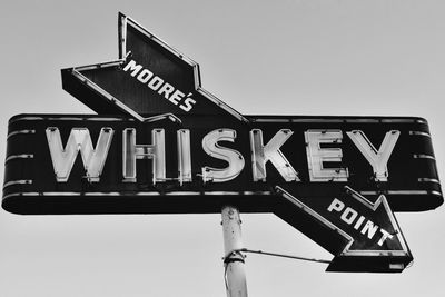 Low angle view of road sign against clear sky