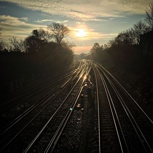 Railroad tracks against sky during sunset