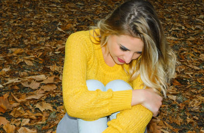 Young woman with yellow leaves during autumn