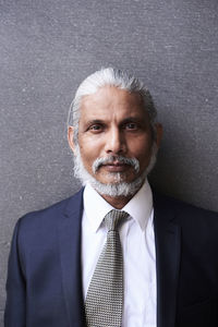 Portrait of senior businessman with grey hair and beard wearing suit and tie