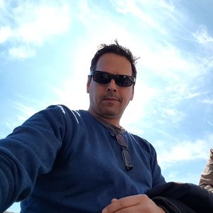 Low angle portrait of young man wearing sunglasses against sky