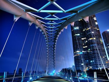 Modern bridge in city against sky at dusk