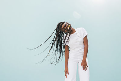 Midsection of woman standing against white background