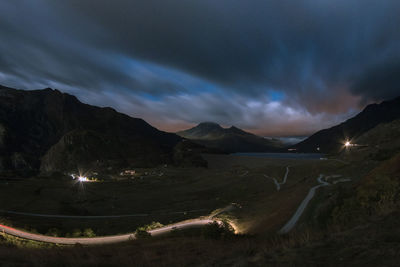 Panoramic view of illuminated mountains against sky at night