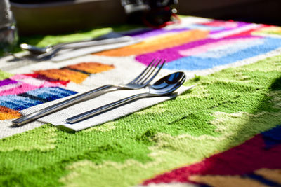 Close-up of eating utensil on colorful tablecloth